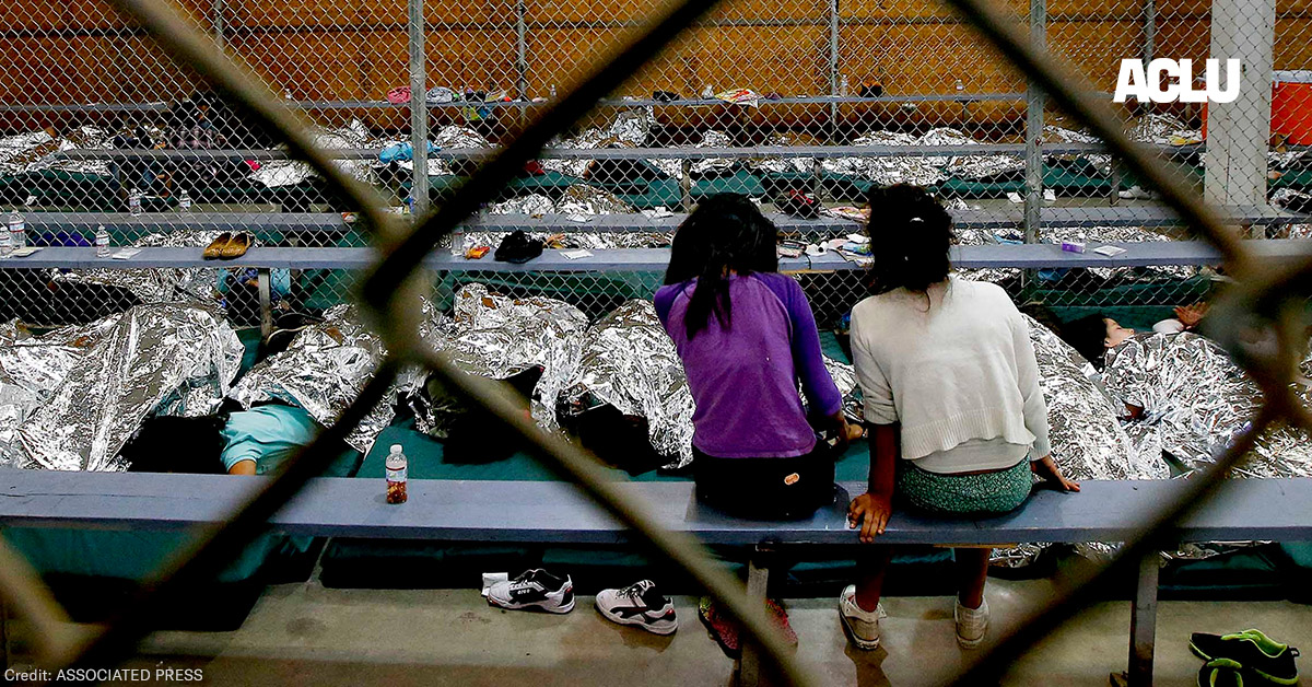 Two young girls watch a World Cup soccer match on a television from their holding area where hundreds of mostly Central American immigrant children are being processed and held