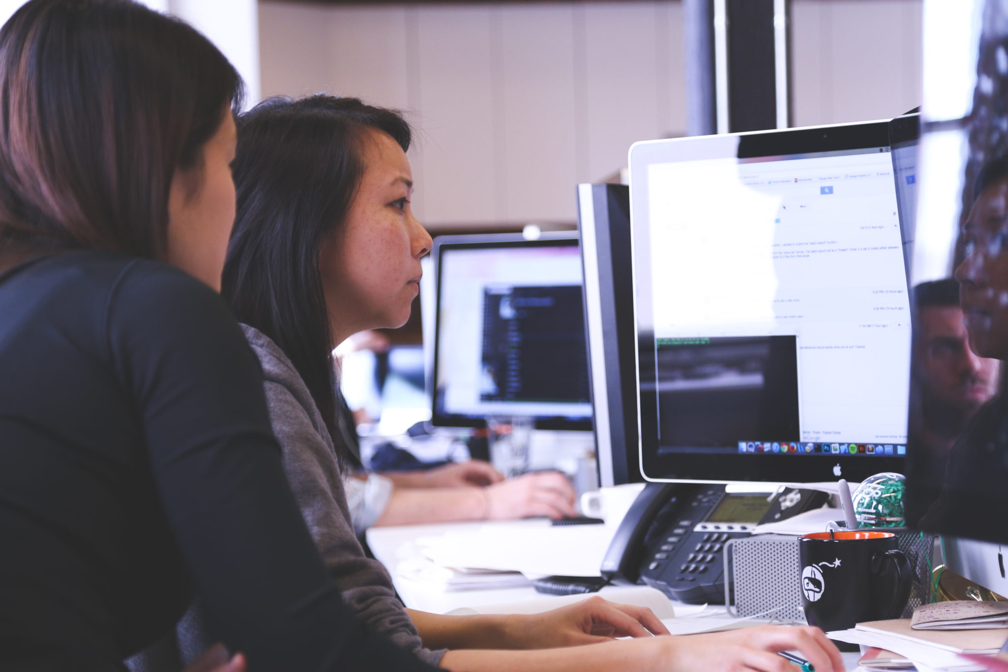 Two women look at computer 